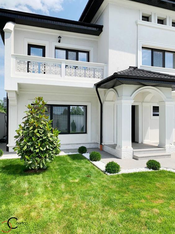 Fachada de casa com pintura branca e elementos  